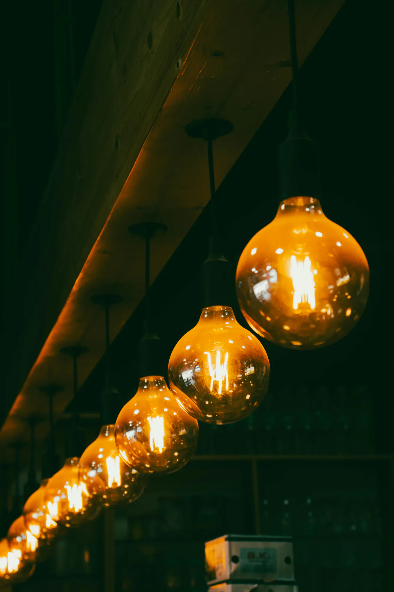 A row of warm Edison bulbs hanging from a wooden ceiling